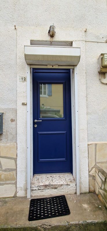 Pose par Colombeau Alu d'une porte d’entrée de couleur bleu foncé texturer de la marque KLINE